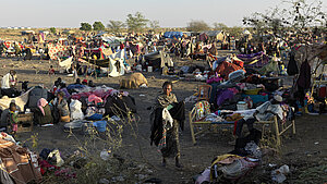 Viele Menschen sitzen und liegen auf dem Boden eines behelfsmäßigen Lagers in Südsudan.