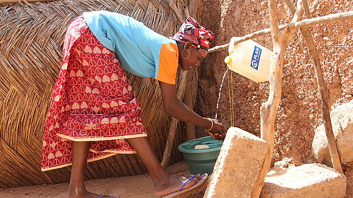 Larissa, 13, wäscht ihre Hände an einer Handwaschstation (Tippy Tap). 