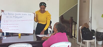 Eine junge Frau präsentiert ein selbstgestaltetes Plakat