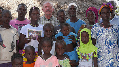Die Großfamilie von Mariama mit Johann Schupfner in ihrer Mitte. Mariama hält einen Brief ihres Paten in den Händen. Die Großfamilie von Mariama mit Johann Schupfner in ihrer Mitte. Mariama hält einen Brief ihres Paten in den Händen.