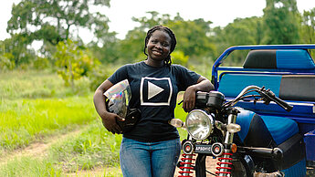 Olivia, 24, mit ihrem speziell erweiterten Motorrad, was sie für die Landwirtschaft nutzen kann. Sie hat es im Rahmen des "Green Skills"-Projekts von Plan International erhalten.
