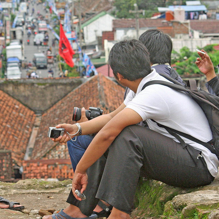 Junge Menschen in Java in Indonesien blicken auf eine Stadt 