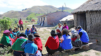 Gruppe indigener Ecuadorianer:innen im Halbkreis sitzend
