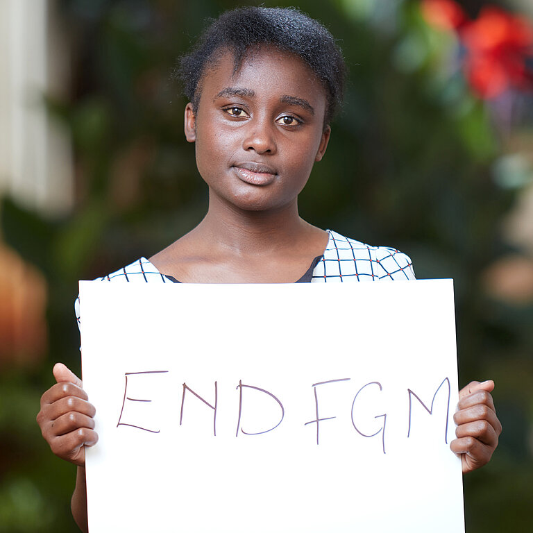 Frau mit Schild "End FGM"