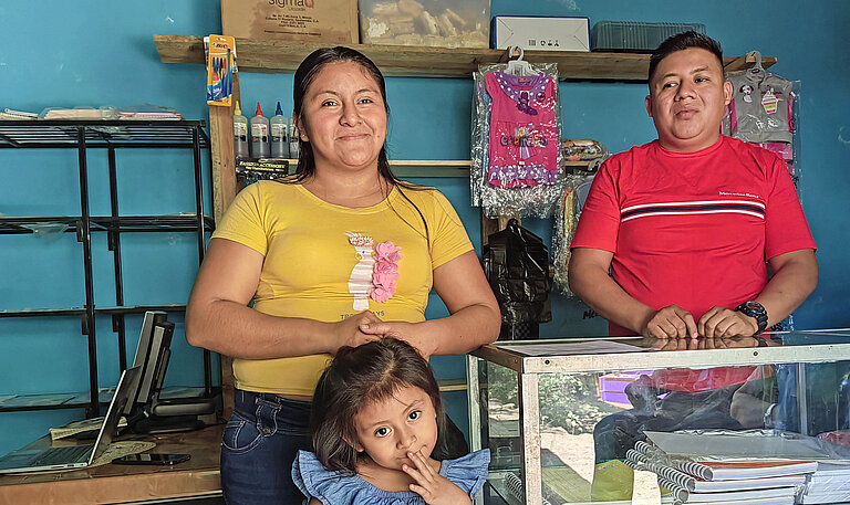 Eltern und ein niedliches kleines Mädchen stehen lächelnd in einem Laden