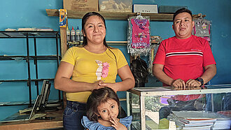 Eltern und ein niedliches kleines Mädchen stehen lächelnd in einem Laden