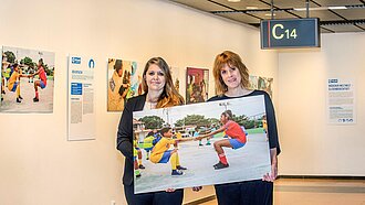 Angi Nickel und Julia Engel (Plan International Deutschland) beim Aufbau der Ausstellung „Mädchen weltweit - gleichberechtigt!“ - die bis Ende Dezember im Hamburger Flughafen zu sehen ist. © Michael Penner.