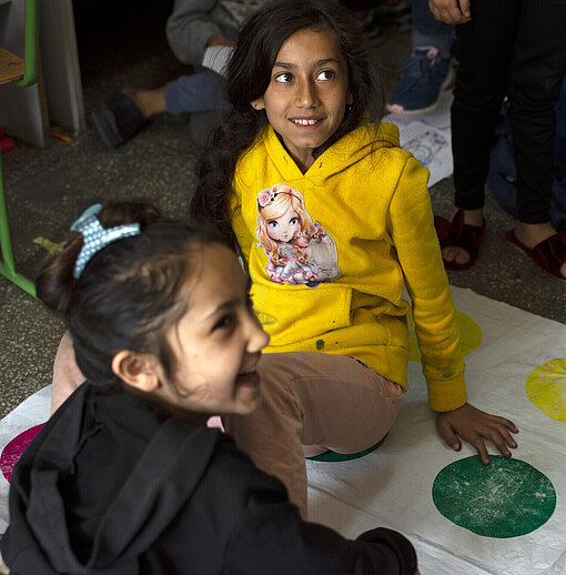 Mädchen spielen Zwei Mädchen spielen das Spiel Twister