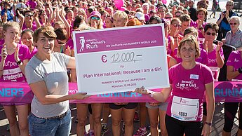 Eventmanagerin Stephanie Fahnemann übergibt Plan-GF Maike Röttger (v.r.) einen Spenden-Scheck über 12.000 Euro. © Plan / Norbert Wilhelmi 