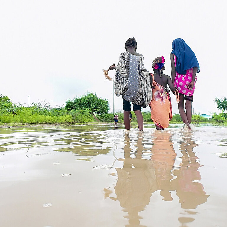 Frauen waten bis zu den Knöcheln im Wasser