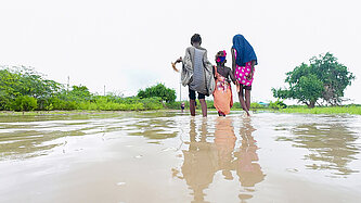 Frauen waten bis zu den Knöcheln im Wasser