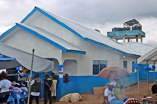 Im liberianischen Todee wird die neu geschaffene „Friedenshütte“ ihrer Bestimmung übergeben Ein weiß gestrichenes Haus, vor dem Menschen stehen