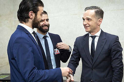 Karim schüttelt Außenminister Heiko Maas die Hand.