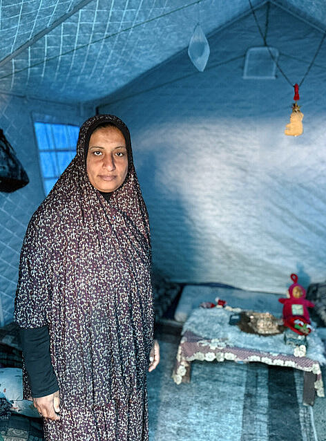 Eine Frau in Gaza steht in ihrem Zelt 