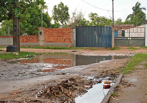 Große Pfützen blockieren einen sandigen Weg