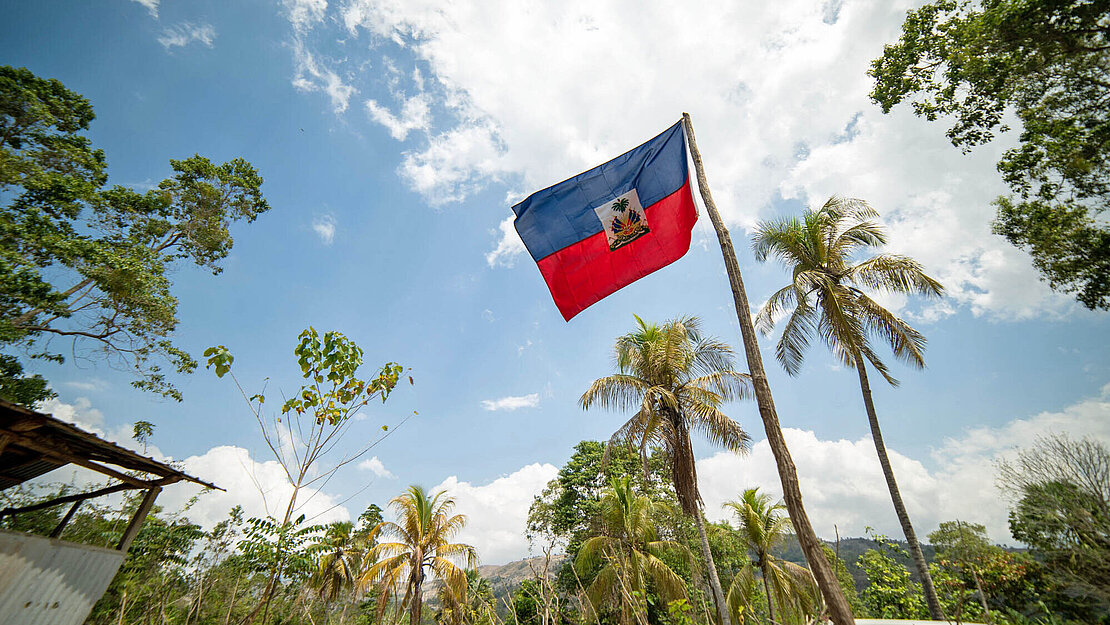 Die Fahne von Haiti weht vor einer Schule