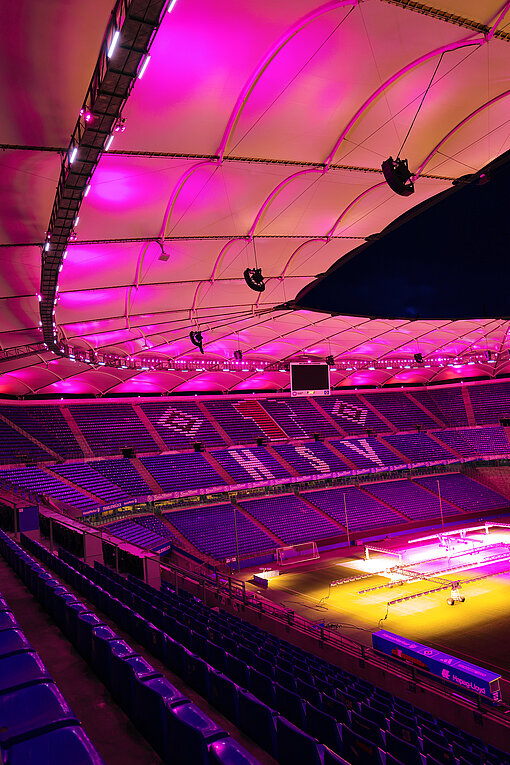 Tribünen eines pink erleuchteten Fußballstadions