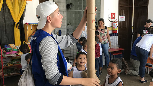 Mauritz baut Turm aus Pappdosen mit Kindern.