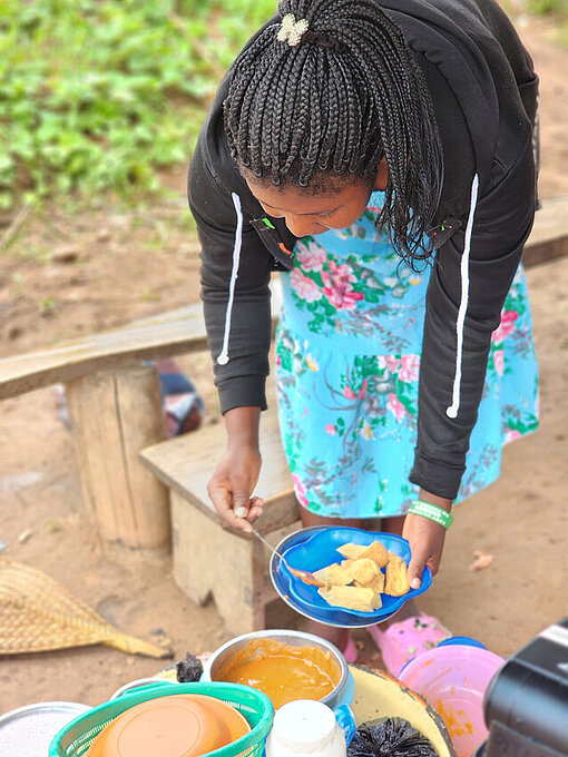 Christine ist stolz auf ihre selbstgemachten Snacks, die sie in ihrem Dorfladen verkauft Frau aus Togo serviert Essen aus ihrem Imbiss