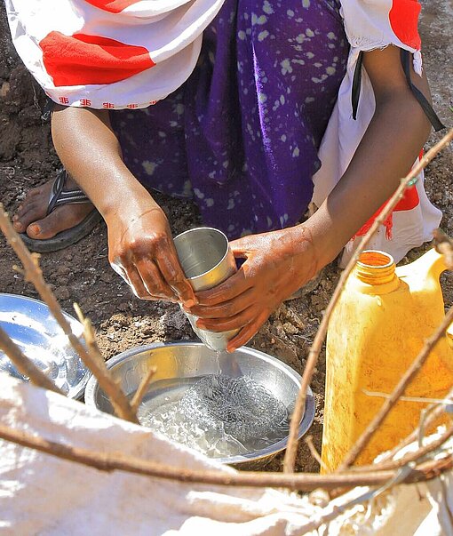 Nuru* (11) hilft ihrer Mutter bei der Hausarbeit Ein Mädchen wäscht ab