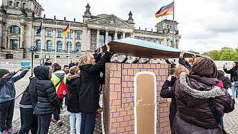 Globale Bildungskampagne: Weltklasse! Bildung darf nicht warten - Aktion vor dem Reichstagsgebäude in Berlin: Ein Schulgebäude wird wieder aufgebaut.