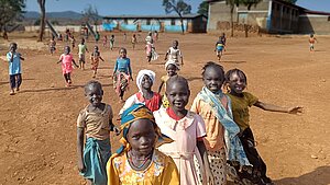 Geflüchtete Kinder in Ura, die mit Freude auf die Betrachter*in zugelaufen kommen.