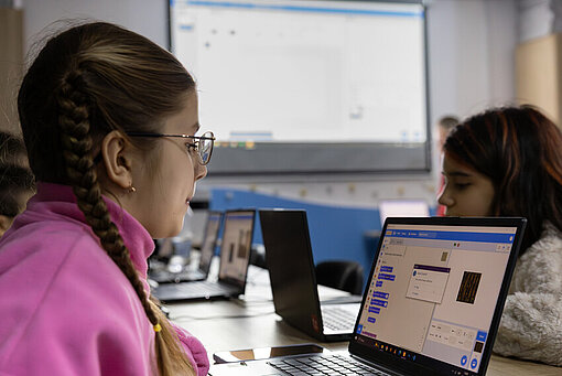 Ein Mädchen aus dem Kinderschutzraum sitzt an einem Laptop