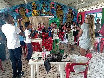 Kinder singen und klatschen in einem Versammlungsraum