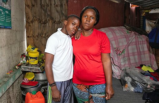 Steeve* (14) ist stolz darauf, dass seine Mutter nicht zu den kriminellen Gruppen in Haiti gehört Ein Junge lehnt an seiner Mutter