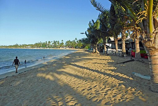 Blick auf einen paradiesischen Sandstrand mit Palmen