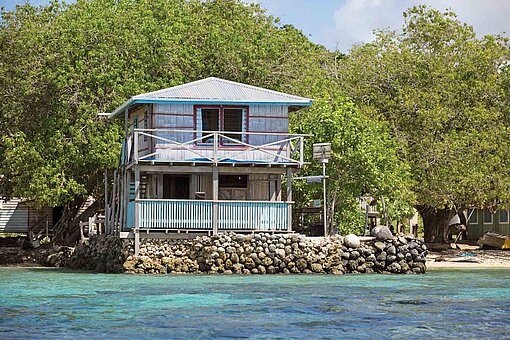 Als Reaktion auf den Anstieg des Meeresspiegels werden entlang der Küsten des Indopazifiks die Häuser auf erhöhte Fundamente angehoben oder landeinwärts verlegt Ekin Haus auf Steinen am Strand