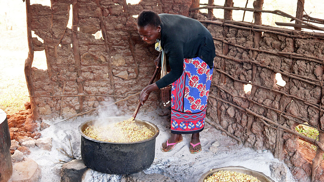 Die Frauen aus dem Dorf bereiten das Mittagessen für die Schulkinder zu