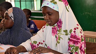 Ein Mädchen sitzt an einem Tisch und liest