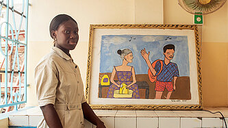 Eine junge Frau steht vor einem gerahmten Kunstwerk