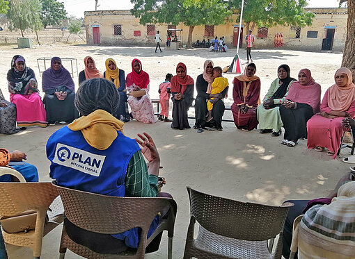 Plan-Teams leisten in Sudan Lebensberatung für Familien auf der Flucht Frauen sitzen im Kreis