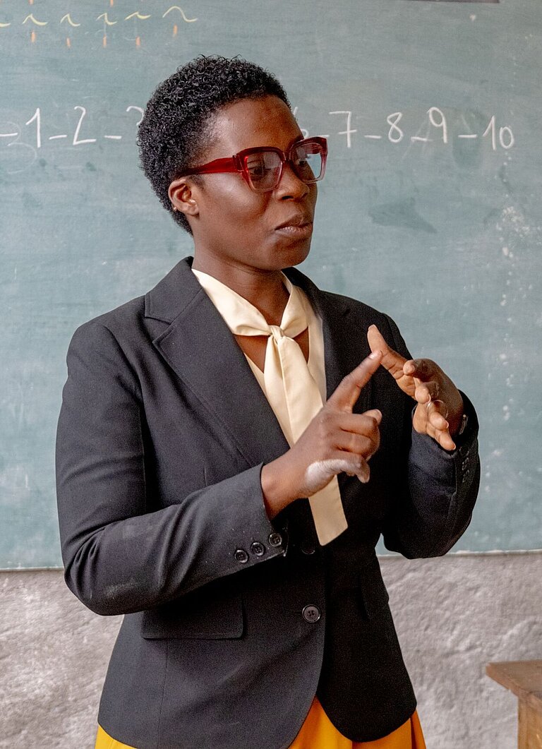 Eine Lehrerin erklärt das Zehn-Finger-Zählsystem