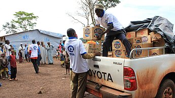 Plan-Teams vergeben Nahrungsmittel und andere Hilfsgüter an die Flüchtlinge in Kamerun. 