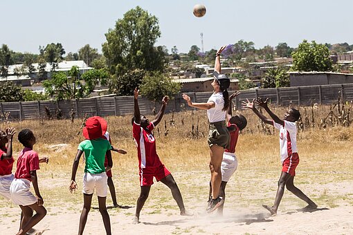 Einige Mädchen spielen mit einer Frau Handball