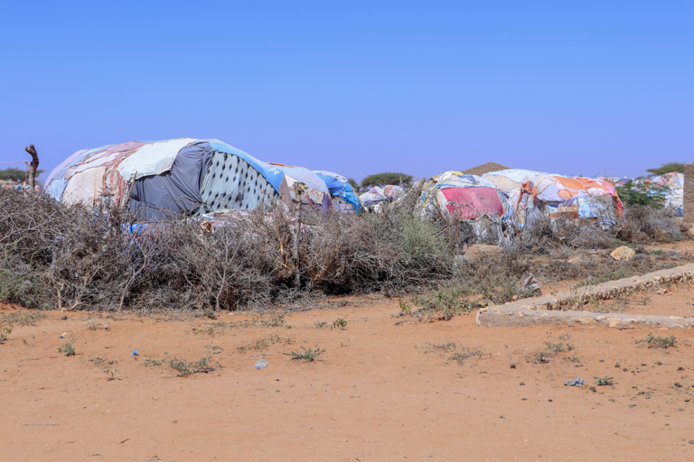 Blick auf trockenen Sandboden und Hütten im Geflüchteten-Camp