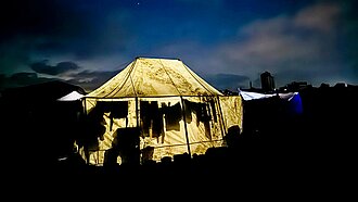 Ein erleuchtetes Zelt bei Nacht in der Nähe eines Verteilungspunkts in Gaza