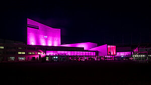 Bregenzer Festsoielhaus ist bei Nacht pinkt beleuchtet.