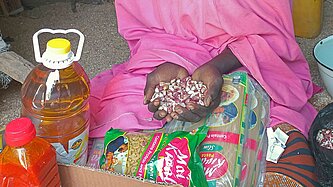 Die Hände einer Frau in rosa Kleid halten eine Handvoll Erdnüsse