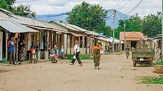 Blick auf eine sandige Dorfstraße mit einfachen kleinen Häusern