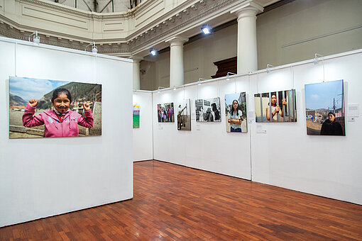 Das Bild zeigt einen Ausschnitt einer Fotoausstellung: Auf weißen Wänden hängen mehrere Fotos