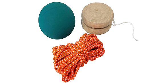 Dreiteiliges Spielzeug-Set für draußen Grüner Flummi, aufgerollter orangefarbener Gummitwist und Jojo aus Holz, natur