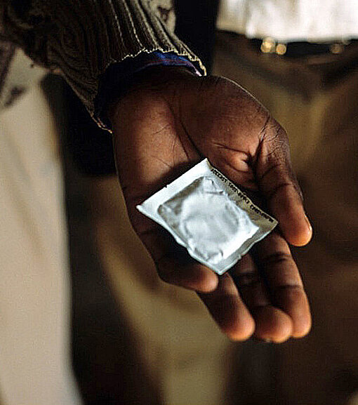 Kondome schützen vor sexuell übertragbaren Krankheiten wie HIV/Aids Ein Mann hält ein Kondom
