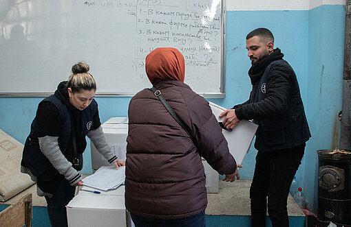 Eine Frau in Syrien erhält von Hilfskräften eine Box mit wichtigen Hygiene-Utensilien wie Zahnbürste, Seife und Periodenprodukte Eine Frau erhält Hilfsgüter von Freiwilligen