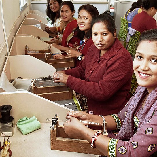 Frauen der Kooperative „Beads for Life“ in Nepal bei der Handarbeit.