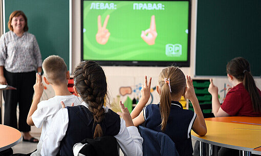 Zusammen mit der NGO Amicii dei Bambini hat Plan International ein Bildungs- und Integrationsprojekt in Moldawien umgesetzt Kinder sitzen in einem Klassenzimmer und beteiligen sich am Unterricht