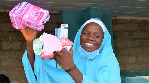 Habiba zeigt ihre Hygieneartikel, die sie von Plan International bekommen hat. 